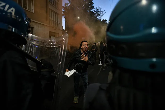A man confronts police officers during a protest against the so-called Green Pass in Milan on October 16, 2021 as all workers must show since October 15 a so-called Green Pass, offering proof of vaccination, recent recovery from Covid-19 or a negative test, or face being declared absent without pay. (Photo by Piero Cruciatti/AFP Photo)