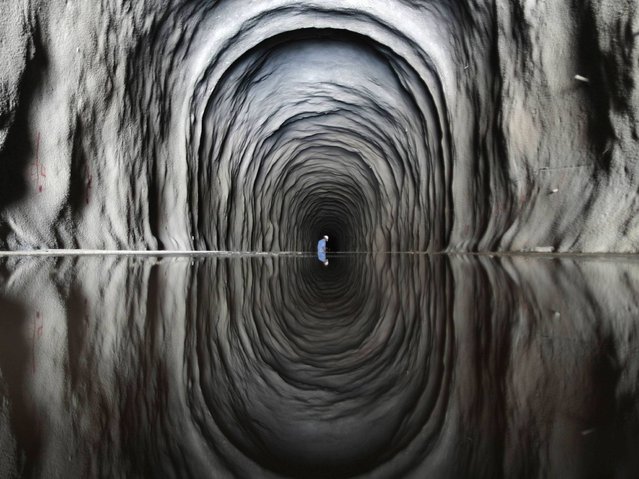 A worker is seen inside the Cuncas II tunnel that will link the canals being built to divert water from the Sao Francisco river for use in four drought-plagued states, a project that is three years behind schedule and has doubled in cost from the original estimate of $3.4 billion, near the city of Mauriti, Brazil, January 28, 2014. (Photo by Ueslei Marcelino/Reuters)