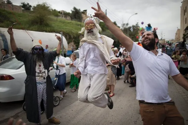 Jewish settlers in costumes dance as they march during the annual Purim parade in the Jewish part of the West Bank city of Hebron, March 24, 2016. The joyful Jewish holiday of Purim celebrates the Jews' salvation from genocide in ancient Persia, as recounted in the Scroll of Esther. (Photo by Abir Sultan/EPA)