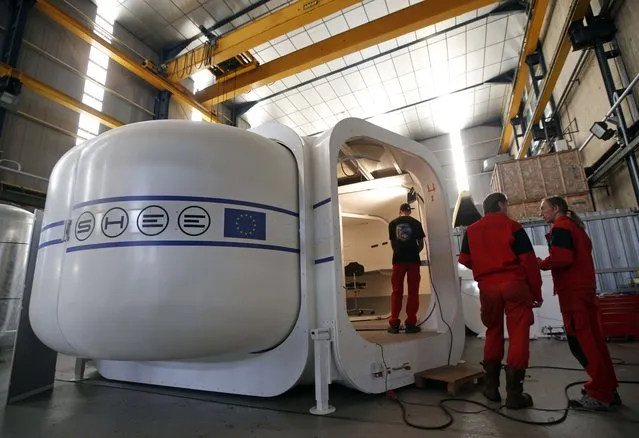Comex Space division manager Peter Weiss (C) talks with a technician as they work on a SHEE structure during test procedures at the Comex, a French company specializing in engineering and deep sea diving operations in Marseille, France, May 13, 2015. The goal of the SHEE project (Self-deployable Habitat for Extreme Environments). (Photo by Jean-Paul Pelissier/Reuters)
