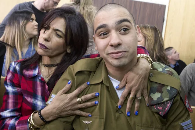Israeli soldier Elor Azaria (R), who shot dead a wounded Palestinian assailant in March 2016, is embraced by his mother Oshra (L) at the start of his sentencing hearing in a military court in Tel Aviv on February 21, 2017. An Israeli military court will sentence a soldier convicted of the manslaughter of a Palestinian attacker in a case which has stoked passions, debate and protest. (Photo by Jim Hollander/AFP Photo)