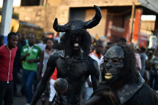 Revelers with their body painted with a mixture of cane sugar syrup and coal depicting the devil while performs in the third and final day of Carnival in the capital of Haiti, Port- au- Prince, on February 28, 2017. (Photo by Hector Retamal/AFP Photo)
