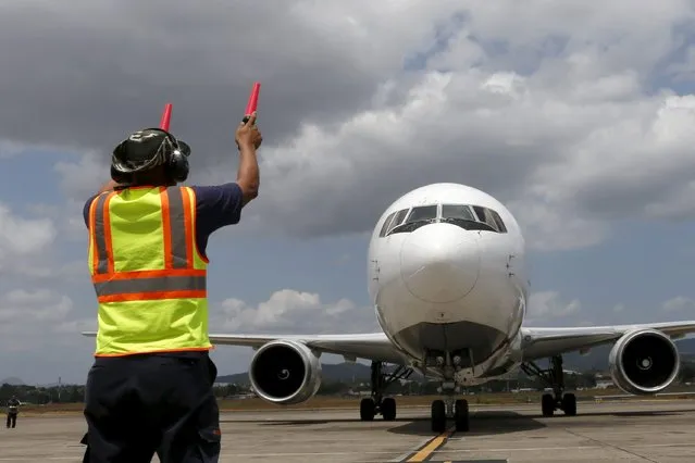 A man gives directions to a cargo aircraft after it landed at Tocumen international airport during an organized media visit in Panama City March 8, 2016. (Photo by Carlos Jasso/Reuters)