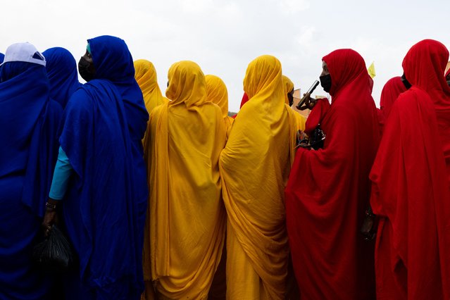 Women wait for the arrival of Mahamat Idriss Déby Itno, transitional president and candidate for the presidential election in Chad, in the stadium under construction in the Dombao district, in Moundou, on April 25, 2024. (Photo by Joris Bolomey/AFP Photo)