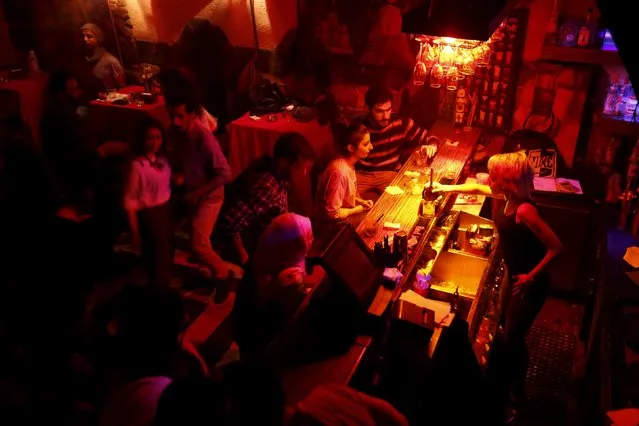 Dana (R), a bartender at Red Bar, pours drinks for customers in Damascus, Syria March 11, 2016. (Photo by Omar Sanadiki/Reuters)