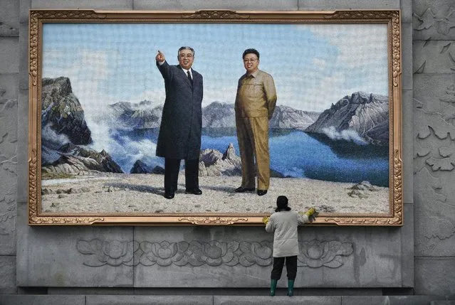 A picture made available on 28 April 2016 shows a woman cleaning the frame of a large mosaic representing former leaders Kim Il-sung (L) and Kim Jong-il at the Mansudae Art Studio in Pyongyang, North Korea, 13 April 2016. Founded in 1959, the Mansudae Art Studio is the largest art production center in the country with a workforce of 4000 including 1000 artists. The production embraces different artistic areas such as oil paintings, bronze sculptures, mosaic, ceramics and embroideries. The majority of the art works exposed in the country have been realized in the studio. (Photo by Franck Robichon/EPA)