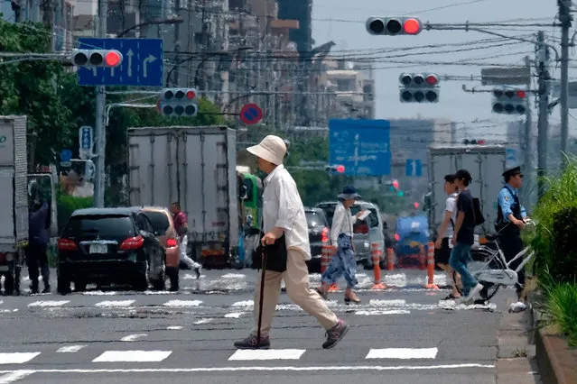 Heat haze distorts the background as pedestrians walk past during a heatwave in Tokyo on July 31, 2019. (Photo by Kazuhiro Nogi/AFP Photo)