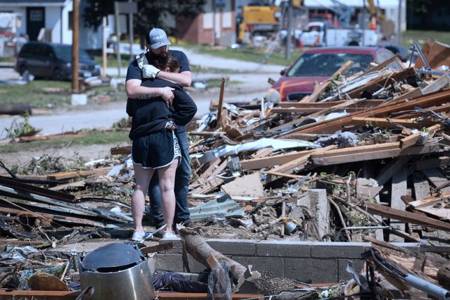 People embrace in front of their home which was destroyed when a tornado tore through town yesterday afternoon on May 22, 2024 in Greenfield, Iowa. Multiple deaths and injuries have been reported from a series of tornadoes and powerful storms that hit several Midwestern states (Photo by Scott Olson/Getty Images)