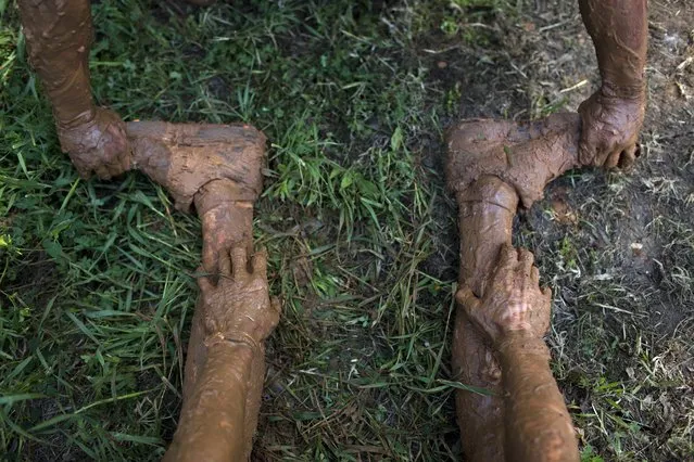 A Participants suffers from a muscle cramp in his leg during the Mud Day race, a 13 kilometer obstacle course in Tel Aviv, Israel, Friday, March 24, 2017. (Photo by Oded Balilty/AP Photo)