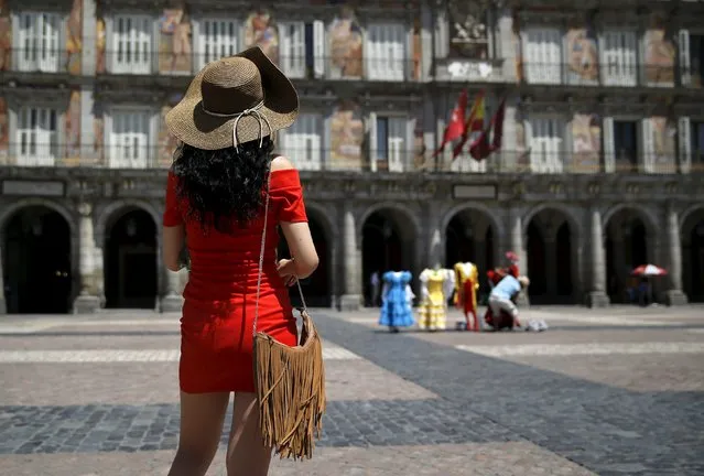A tourist with a hat visits Madrid's landmark Plaza Mayor during a hot summer day in central Madrid, Spain, July 1, 2015. (Photo by Andrea Comas/Reuters)