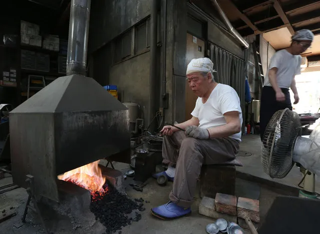 A master Myouchin Munemichi (L), 72, and his son Myouchin Keizo, 38, as they produce Hbashi iron bells made of iron at Myochin Honpo shop on April 25, 2014 in Himeji, Japan. Myochin family's iron business, started in the Heian period (794-1185) of Japan as an armor and helmet maker, shifted as the needs of people changed in the course of history. (Photo by Buddhika Weerasinghe/Getty Images)