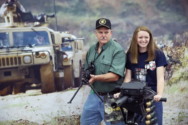 Ernest Belcher poses for a picture with an FN MK 48 machine gun while his daughter Morgan poses with a MK 19 grenade launcher at the NRA Annual Meetings & Exhibits on May 21, 2016 in Louisville, Kentucky. (Photo by Scott Olson/Getty Images)