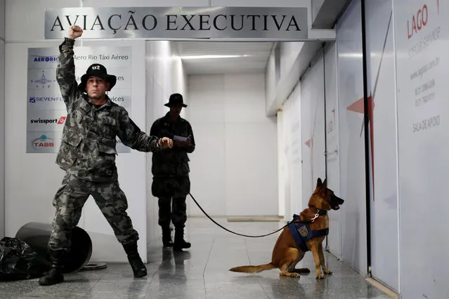 Soldiers of the military police battalion and their dog take part in an instructional exercise with officers of an elite unit of the French police, who is responsible for anti-terrorist actions in France, at Terminal 1 of the Tom Jobim International Airport in Rio de Janeiro, Brazil, May 25, 2016. (Photo by Ueslei Marcelino/Reuters)