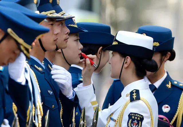 A female honour guard has lipstick applied as they prepare for an official welcoming ceremony for Italy's Prime Minister Matteo Renzi outside the Great Hall of the People in Beijing, June 11, 2014. (Photo by Jason Lee/Reuters)