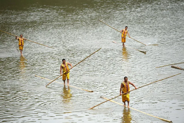 Participants paddle on bamboo poles as they take part in a performance ahead of the Dragon Boat festival at Tanghe Town in Chongqing, China May 27, 2017. (Photo by Chen Chao/Reuters)