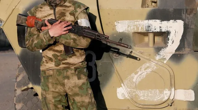 A service member of pro-Russian troops stands guard next to a combat vehicle, with the symbol «Z» seen on its side, before the expected evacuation of wounded Ukrainian soldiers from the besieged Azovstal steel mill in the course of Ukraine-Russia conflict in Mariupol, Ukraine on May 16, 2022. (Photo by Alexander Ermochenko/Reuters)