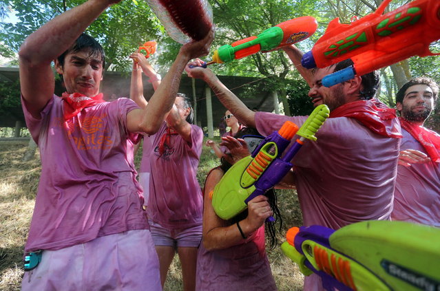 Revelers use toys to spray wine on each other as they take part in the “Battle of Wine” (La batalla del vino de Haro), a wine fight, during the Haro Wine Festival, in Haro, in the northern province of La Rioja on June 29, 2014. More than nine thousand locals and tourists threw around 130.000 litres of wine at each other during the Haro Wine Festival, according to local media. (Photo by Cesar Manso/AFP Photo)