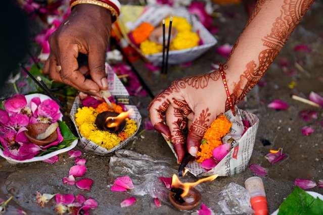 A Hindu woman offers prayers on the occasion of Teej festival, at Sangam, the confluence of rivers Ganges and Yamuna in Prayagraj, India, Friday, September 6, 2024. (Photo by Rajesh Kumar Singh/AP Photo)