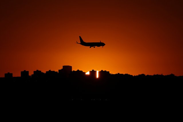 Picture taken on September 8, 2024, shows a plane landing at Barajas airport during sunset in Madrid. (Photo by Thomas Coex/AFP Photo)