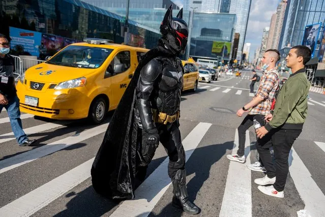 A cosplayer dressed as Batman wearing the Hellbat suit crosses the road during Day 1 of New York Comic Con at Javits Center on October 07, 2021 in New York City. Comic Con has returned this year after being cancelled in 2020 due to the coronavirus pandemic. (Photo by Alexi Rosenfeld/Getty Images)