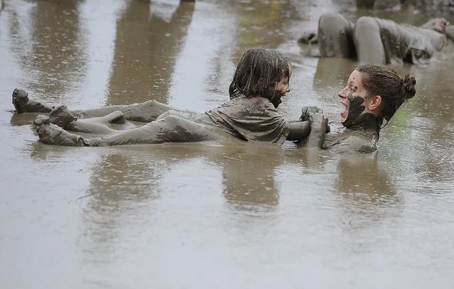 Jody Thomas and her 3-year old daughter, Kailyn Thomas, float around in the mud pit at the annual Wayne County Parks Mud Day at Hines Park- Nankin Mills Area, in Westland, Mich., on Tuesday, July 8, 2014, Kailyn's birthday. (Photo by Daniel Mears/AP Photo/The Detroit News)