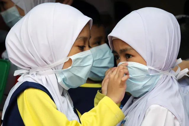 Students cover their faces with masks at a school as haze shrouds Kuala Lumpur, Malaysia, September 13, 2019. (Photo by Lim Huey Teng/Reuters)