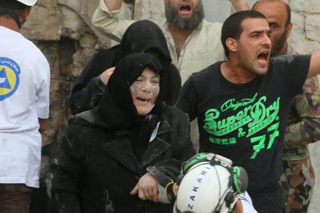 An injured woman reacts after an airstrike on Aleppo's rebel held Kadi Askar area, Syria July 8, 2016. (Photo by Abdalrhman Ismail/Reuters)