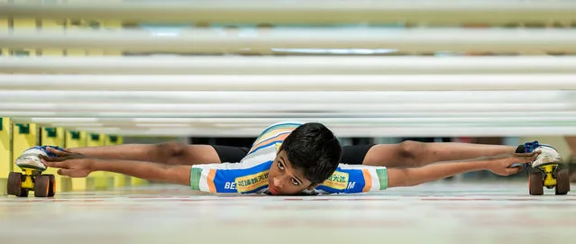 India's Rohan Ajit Kokane, 11, performs in Hong Kong on July 25, 2012, flattening his body until none of it is higher than 6.75 inches off the ground. The event staged in a local shopping mall was aimed at encouraging sport practice among the elderly. (Photo by Philippe Lopez/AFP Photo)