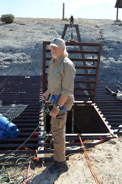 This July 2014 image provided by the Bureau of Land Management shows BLM Paleontologist Brent Breithaupt at the mouth to the interior of the Natural Trap Cave in north-central Wyoming. The cave holds the remains of tens of thousands of animals, including many now-extinct species, from the late Pleistocene period tens of thousands of years ago. Scientists have resumed digging for the first time in more than 30 years. (Photo by AP Photo/Bureau of Land Management)