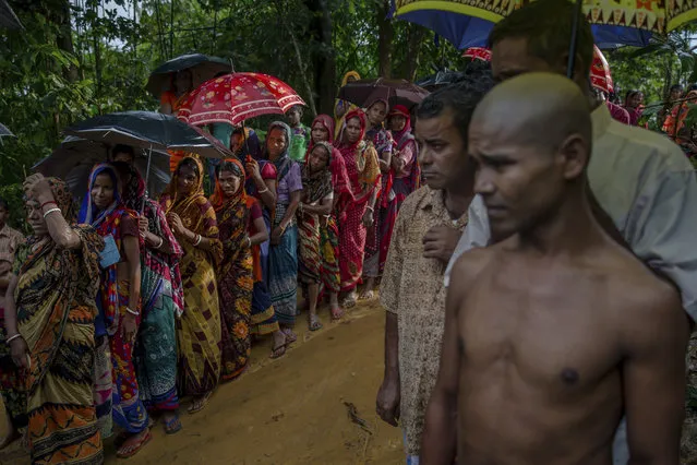 Hindu men and women, who crossed over from Myanmar into Bangladesh, wait for their turn to collect aid at refugee camp set up for Hindu refugees near Kutupalong, Bangladesh, Tuesday, September 26, 2017. (Photo by Dar Yasin/AP Photo)
