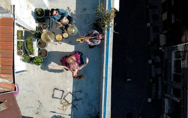 An aerial view of the performance of dancer Su Sevda Uzun from a terrace of her friend's home while she is accompanied by musicians Hakan Kaya and Alper Kalayciklioglu which they organise regularly for their neighbours as the spread of the coronavirus disease (COVID-19) continues in Istanbul, Turkey, April 13, 2020. (Photo by Umit Bektas/Reuters)