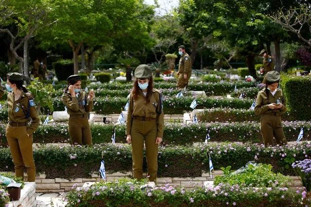 Israeli soldiers wear face masks as they stand next to the graves of fallen soldiers during a ceremony ahead of Memorial Day, which commemorates those who died during conflicts, amid the coronavirus disease (COVID-19) restrictions in Tel Aviv, Israel on April 27, 2020. (Photo by Corinna Kern/Reuters)