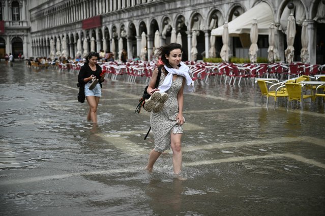 People walk in a flooded St. Mark's square during high tide (aqua alta) on September 5, 2024 in Venice. (Photo by Marco Bertorello/AFP Photo)