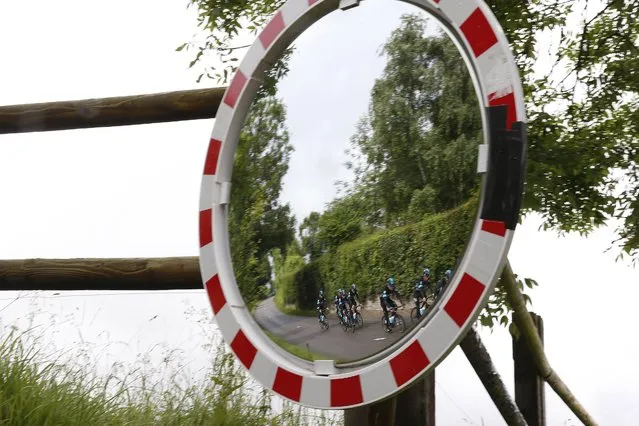 Britain's Chris Froome and his teammates are reflected in a roadside mirror during a training ride two days before the start of the Tour de France cycling race, at the team hotel in Port-en-Bessin-Huppain, France, Thursday, June 30, 2016. (Photo by Christophe Ena/AP Photo)