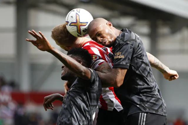 Brentford's Mathias Jensen, center, goes for the header with Arsenal's Thomas Partey, left, and his teammate Gabriel during the English Premier League soccer match between Brentford and Arsenal, at the Gtech Community stadium, London, Sunday, September18, 2022. (Photo by David Cliff/AP Photo)