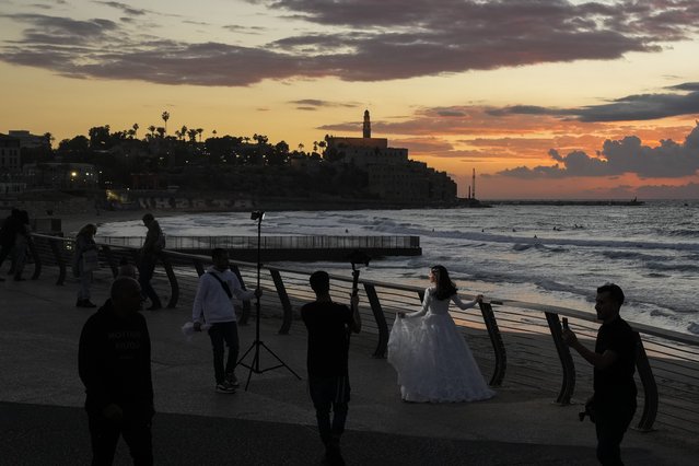 A woman poses for a photo session along a beach in Tel Aviv, Wednesday, December 4, 2024. (Photo by Matias Delacroix/AP Photo)