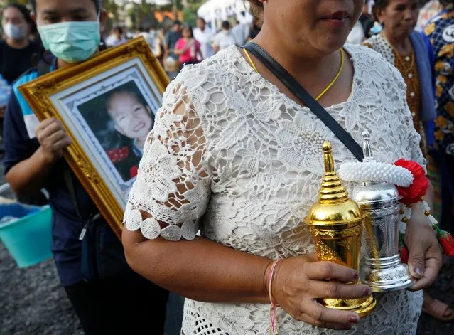 Mass shooting victims families hold cinerary urns as they collect the victims' ashes after the royal sponsored mass cremation at Wat Rat Samakkee temple in Nong Bua Lamphu province, northeastern Thailand, 12 October 2022. At least 37 people, mostly children, were killed, while another 12 people were injured, after a former policeman committed a mass shooting at a children's care center on 06 October. The gunman subsequently killed his wife and their child, then himself, police said. (Photo by Narong Sangnak/EPA/EFE/Rex Features/Shutterstock)