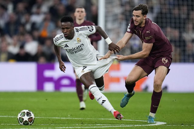 Manchester City's Nico Gonzalez, right, challenges Real Madrid's Vinicius Junior during the Champions League playoff second leg soccer match between Real Madrid and Manchester City at the Santiago Bernabeu Stadium in Madrid, Spain, Wednesday, February 19, 2025. (Photo by Manu Fernandez/AP Photo)