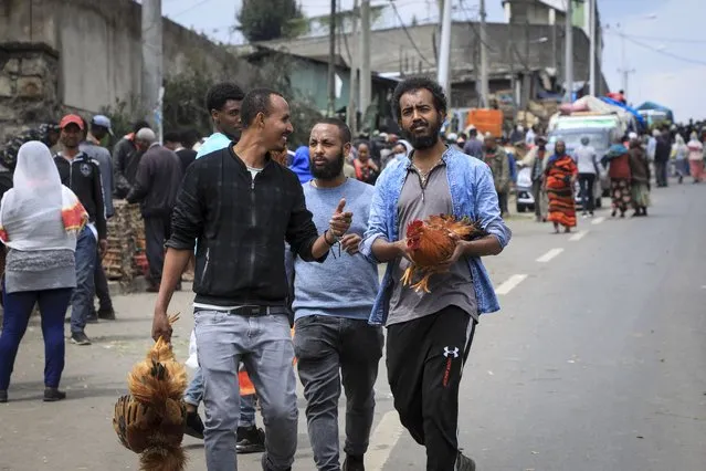 Men carry chickens home after buying them at Sholla Market, the day before the Ethiopian New Year, in Addis Ababa, Ethiopia Saturday, September 10, 2022. Once home to one of Africa's fastest growing economies, Ethiopia is struggling as the war in its Tigray region has reignited and Ethiopians are experiencing the highest inflation in a decade, foreign exchange restrictions and mounting debt amid reports of massive government spending on the war effort. (Photo by AP Photo/Stringer)