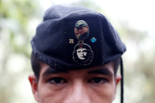 Eduar, a member of the 51st Front of the Revolutionary Armed Forces of Colombia (FARC), is seen wearing a cap with badges showing images of Che Guevara and FARC's late founder Manuel Marulanda at a camp in Cordillera Oriental, Colombia, August 16, 2016. (Photo by John Vizcaino/Reuters)