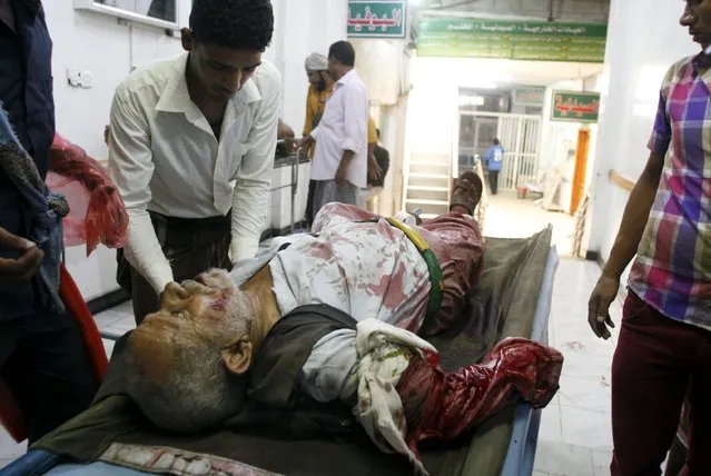 A volunteer helps a man injured by a shell that landed in a residential area during fighting between Houthi militants and pro-government militants in Yemen's southwestern city of Taiz September 24, 2015. (Photo by Reuters/Stringer)