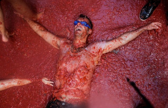 A reveller lies in tomato pulp during the annual “Tomatina” festival in Bunol near Valencia, Spain, August 31, 2016. (Photo by Heino Kalis/Reuters)