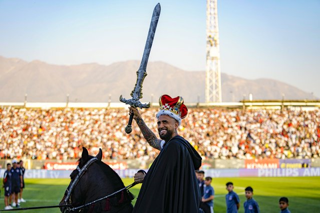 Chilean soccer player Arturo Vidal waves a sword while riding a horse on to the pitch at his welcoming event at the Monumental Stadium in Santiago, Chile, Thursday, February 1, 2024. Vidal returns to play for Colo Colo after 17 years of a successful career playing for soccers clubs in Europe and South America. (Photo by Esteban Felix/AP Photo)