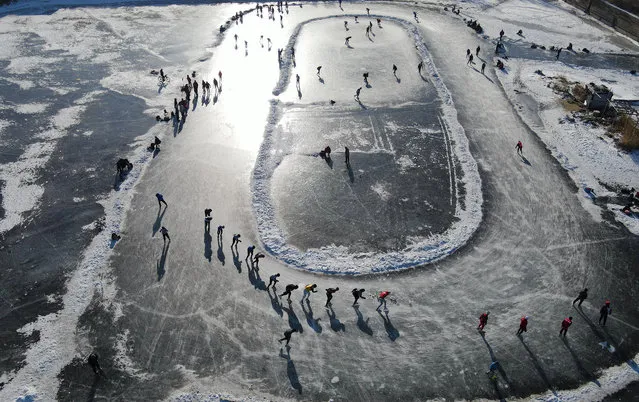 Aerial photo shows many citizens enjoying the fun of skating on the natural ice field formed by wetlands around Songhua River in Harbin City, northeast China's Heilongjiang Province on December 8, 2022. (Photo by Rex Features/Shutterstock)