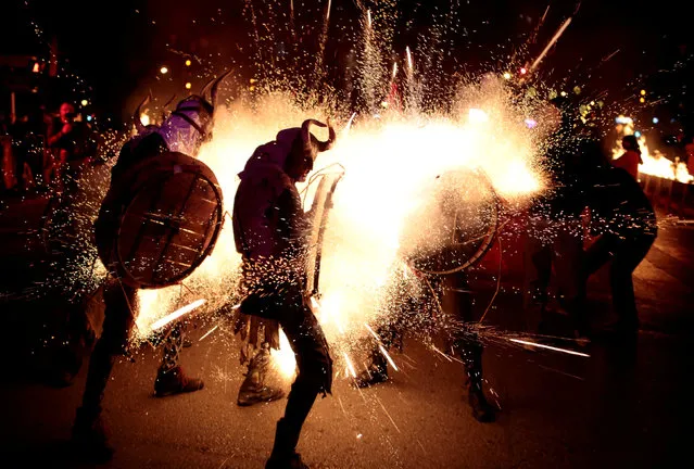 Revellers dressed as devils walk among fireworks during “Correfocs” (fire runs), traditional celebrations in eastern Spain with people dressed as dancing devils while lighting fireworks among crowds of spectators, to mark the end of the local festivities in Palma de Mallorca, Spain, January 21, 2018. (Photo by Enrique Calvo/Reuters)