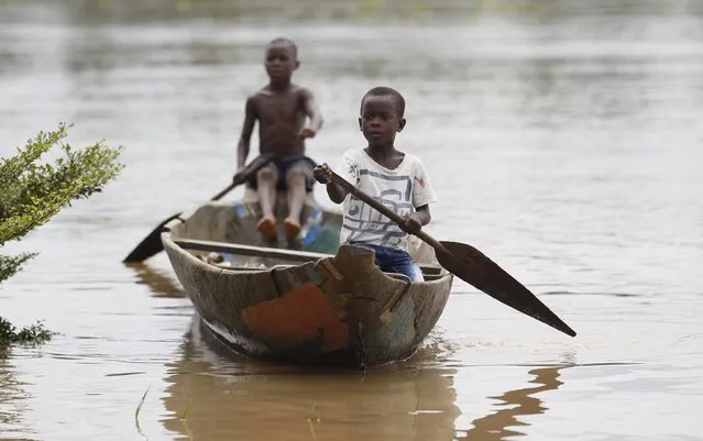 Boys paddle a canoe near the shore of the Nun River in Yeneka village in Nigeria's Bayelsa state October 8, 2015. (Photo by Akintunde Akinleye/Reuters)