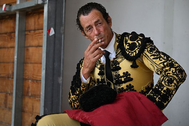 A peone (assistant bullfighter) smokes a cigarette before the bullfight in Lunel, southern France, on July 20, 2025. (Photo by Gabriel Bouys/AFP Photo)