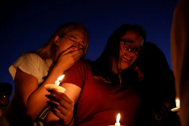 Students mourn during a candlelight vigil for victims of yesterday's shooting at nearby Marjory Stoneman Douglas High School, in Parkland, Florida, February 15, 2018. (Photo by Carlos Garcia Rawlins/Reuters)