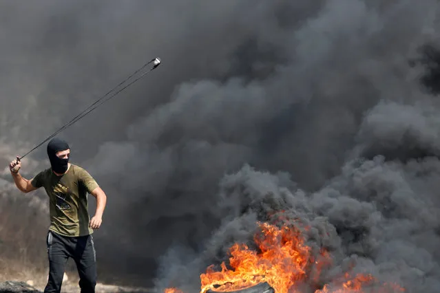 A Palestinian demonstrator uses a sling to hurl stones at Israeli troops during protest against Jewish settlements and normalizing ties with Israel, in Kafr Qaddum town in the Israeli-occupied West Bank on September 18, 2020. (Photo by Raneen Sawafta/Reuters)