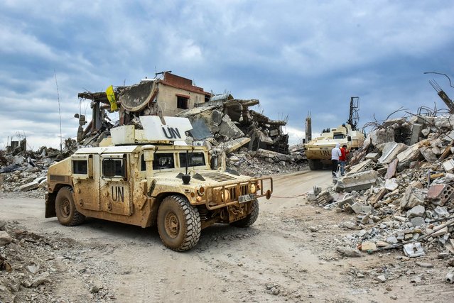 UNIFIL vehicles drive past the rubble of destroyed buildings in the southern Lebanese village of Yaroun near the border with Israel on February 19, 2025. Israeli forces withdrew from a series of border villages including southeast Lebanon's Odaisseh, Kfar Kila, Mais al-Jabal, Markaba and Hula under an extended ceasefire deadline that expired on February 18, but remained in five points near the border. (Photo by Fadel Itani/AFP Photo)